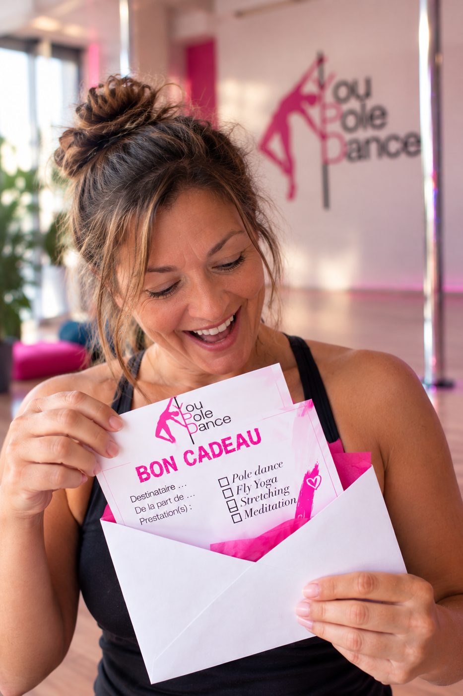 Femme ravie découvrant son bon cadeau You Pole Dance au studio