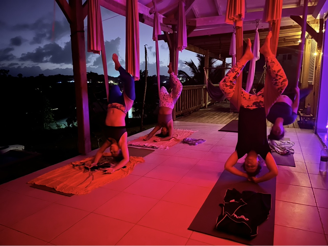 Cours de Fly Yoga en groupe au studio, ambiance nocturne
